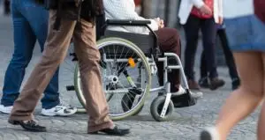 Life in motion: a person in a wheelchair navigating through a busy urban street with the bustle of pedestrians around.