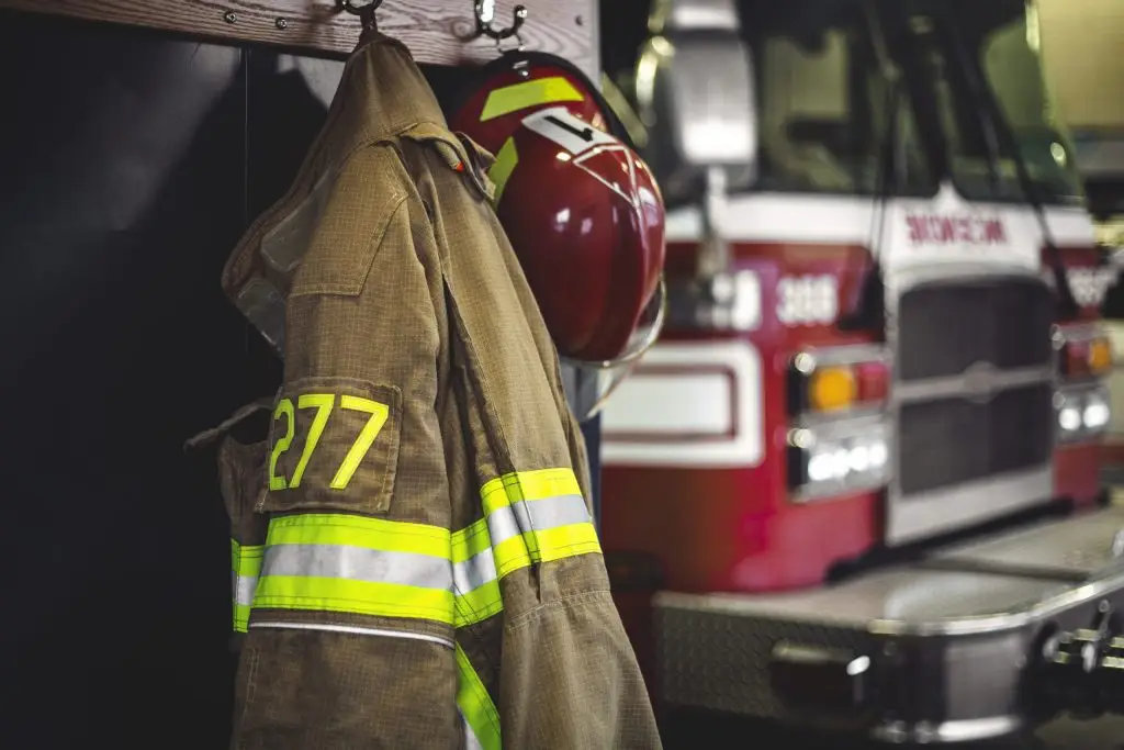 Firefighter's gear ready for action, with a fire truck in the background.